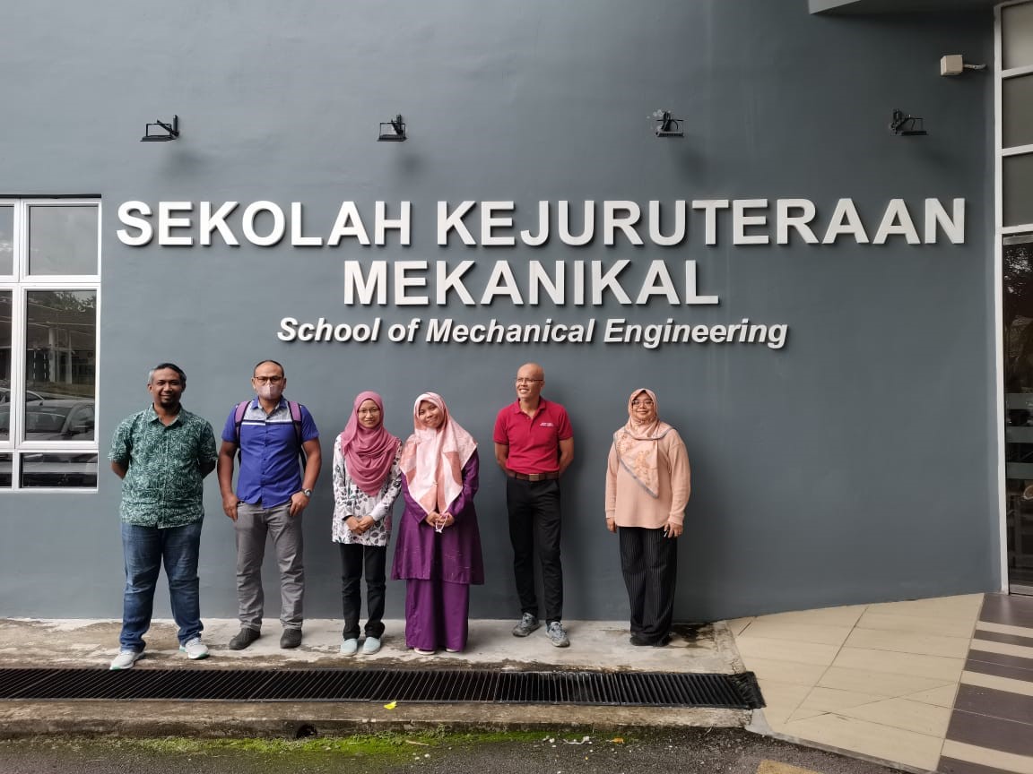 A group of people posing for a photo in front of a building Description automatically generated